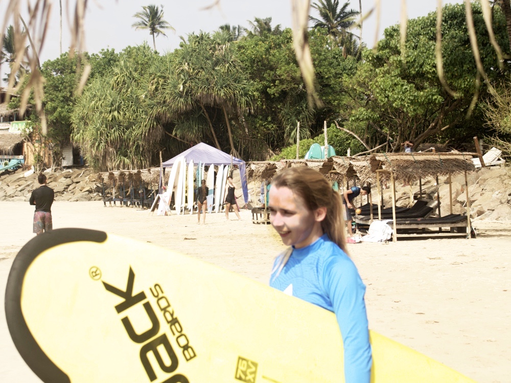 Girl with surf board in Ahangama, Sri Lanka